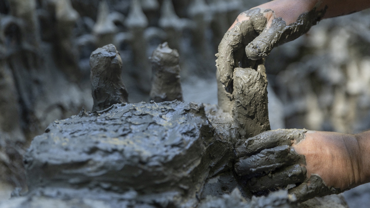 Land art artist Francois Monthoux works on his 'Monthoux castle' made out of clay retrieved from the dried bed of Le Toleure river due to ongoing drought, in Saubraz, Switzerland. Credit: Reuters Photo