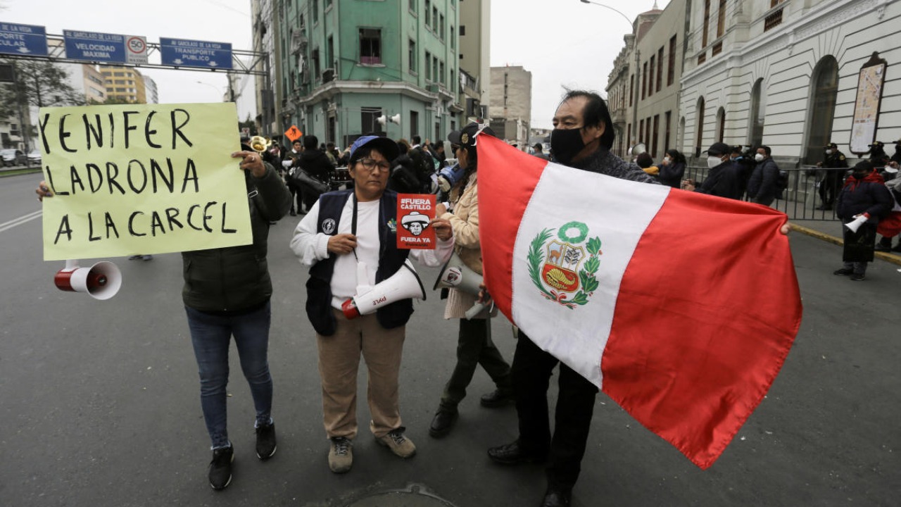 A demonstrator holds a sign reading