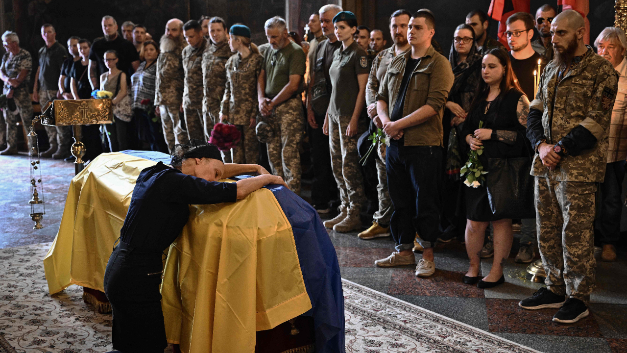 Nadiya, the mother of late Ukrainian serviceman Roman Barvinok, mourns at his coffin during a funeral service in St. Michael's Golden-Domed Cathedral in Kyiv on August 28, 2022, amid the Russian invasion of Ukraine. Credit: AFP Photo
