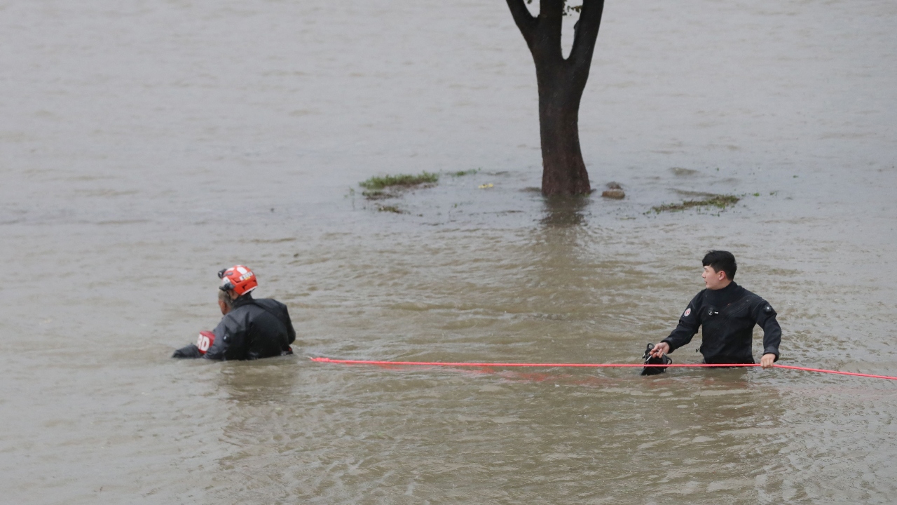 South Korean rescue workers rescue a man from a flooded riverside park in Ulsan. Credit: AFP Photo