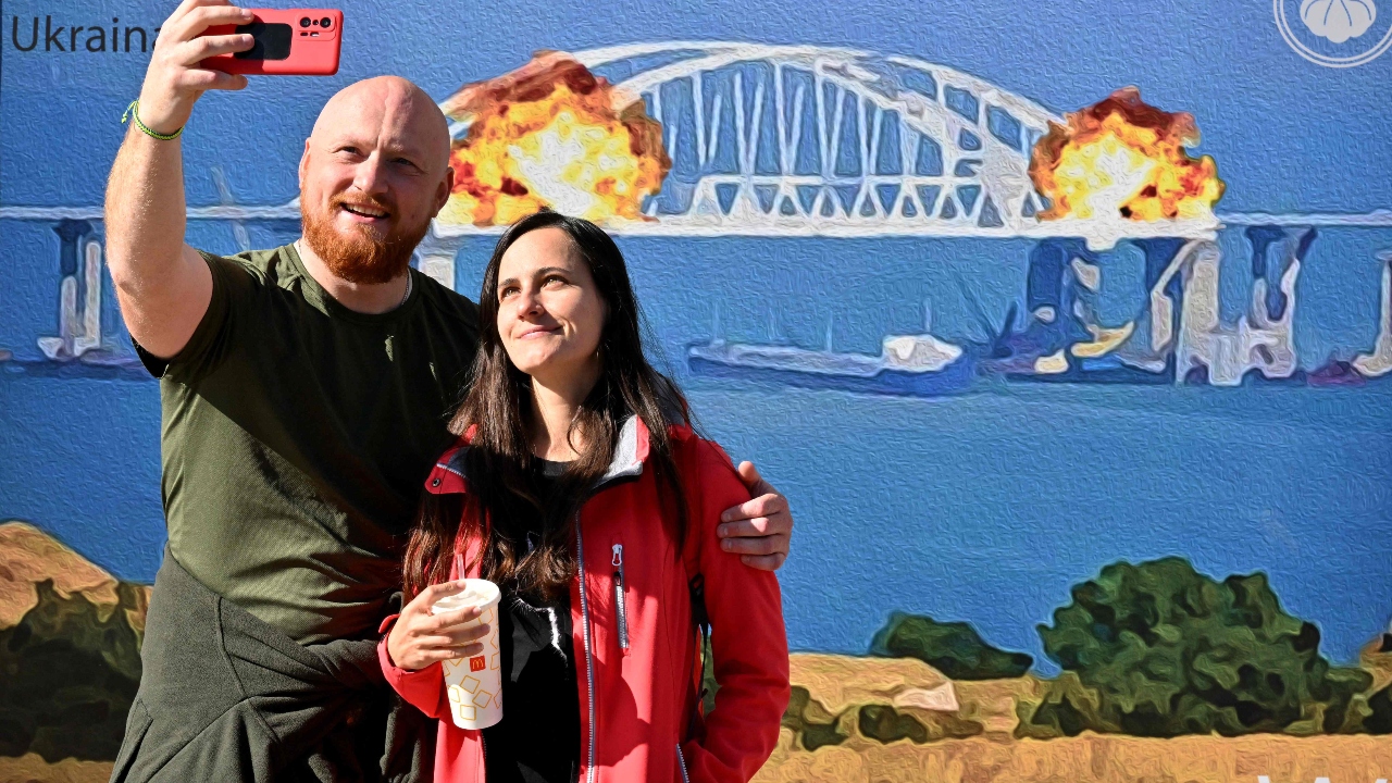 A couple took selfies in front of the artwork shaped like a big stamp named “Cotton to the Crimean Bridge. Credit: AFP Photo