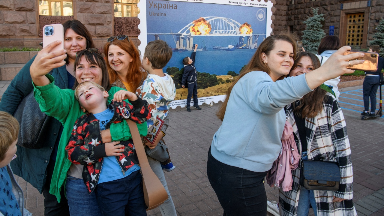 Several families, couples, children were spotted getting clicked all around the artwork of the burning bridge. Credit: Reuters Photo