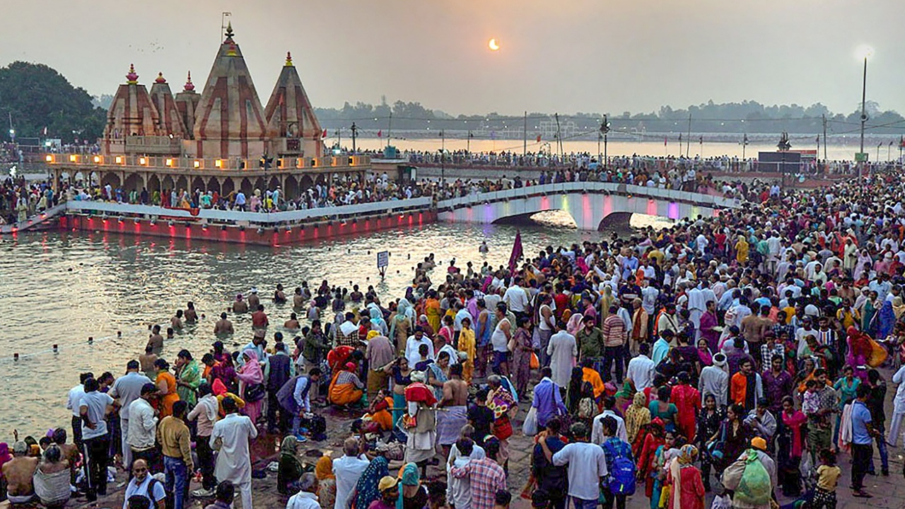 Devotees gather to take a bath in the Brahmasarovar during a partial solar eclipse in Kurukshetra. Credit: PTI Photo