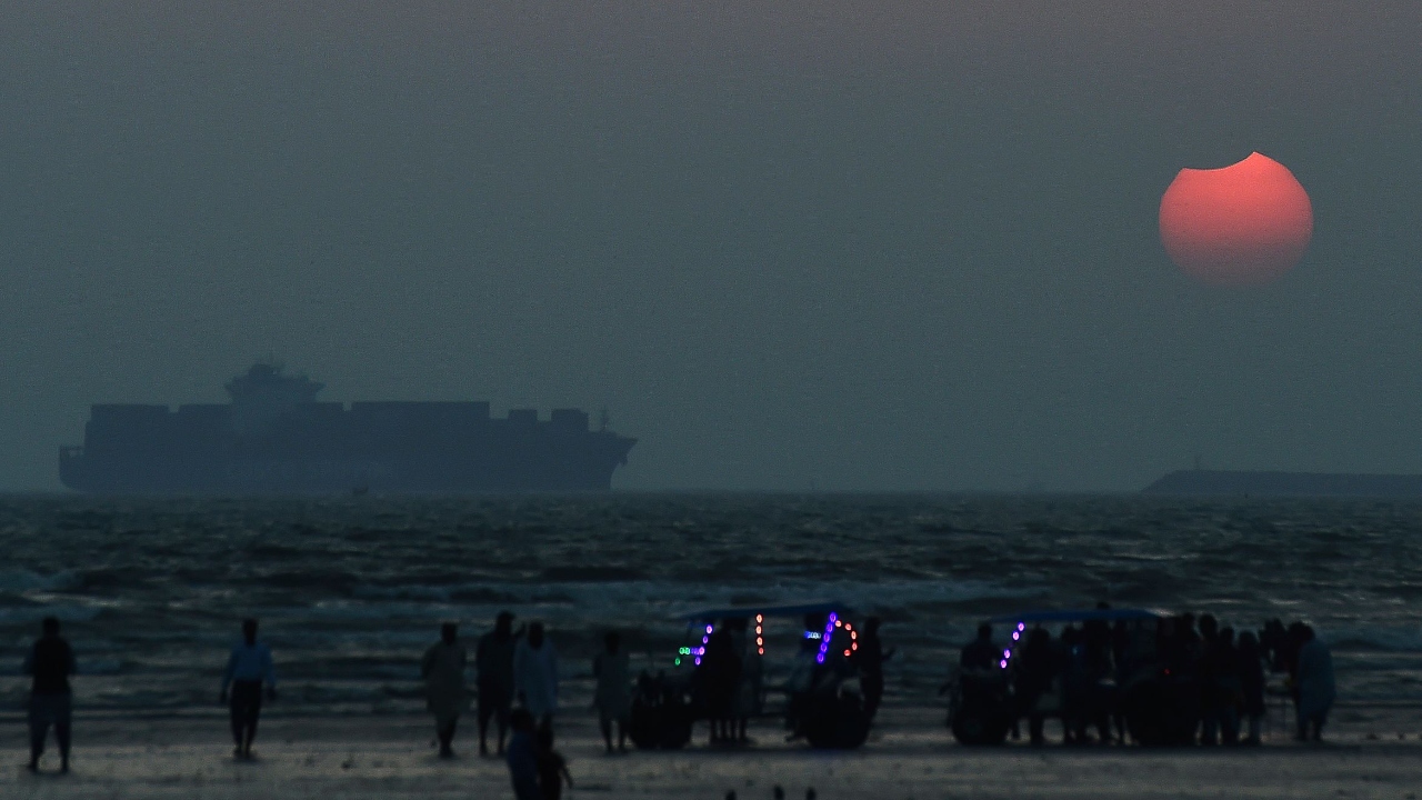 The moon partially obscures the sun during the partial solar eclipse visible from a beach in Karachi. Credit: AFP Photo
