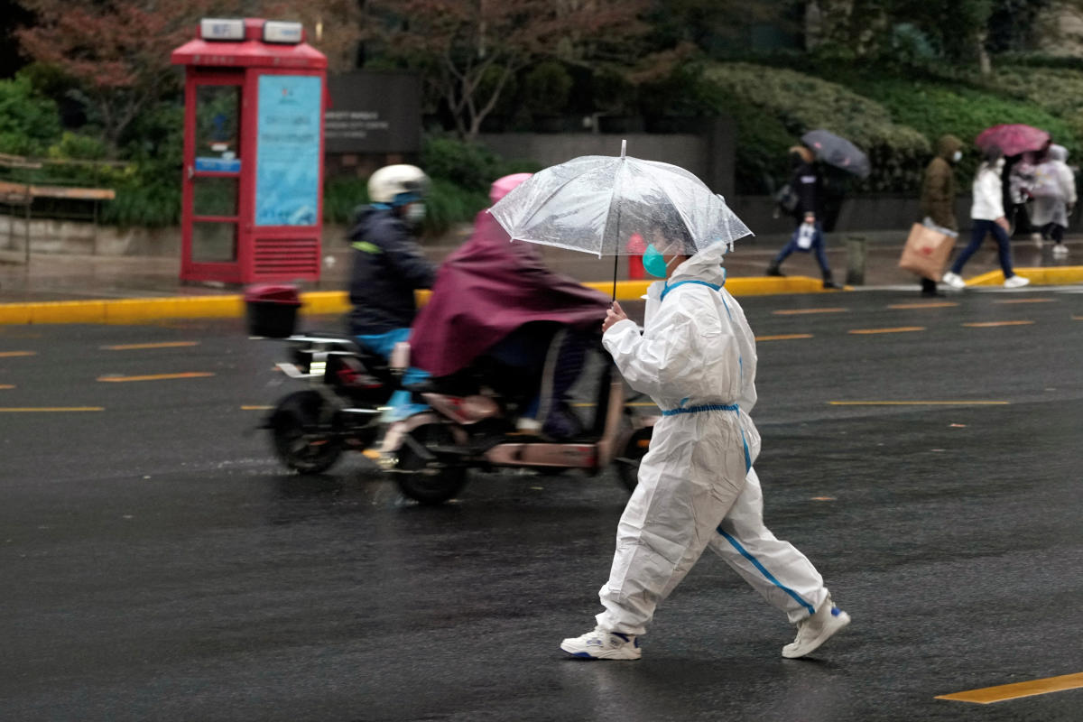 A person in a protective suit crosses a road in the rain, amid the coronavirus disease (COVID-19) outbreak in Shanghai, China. Credit: Reuters Photo