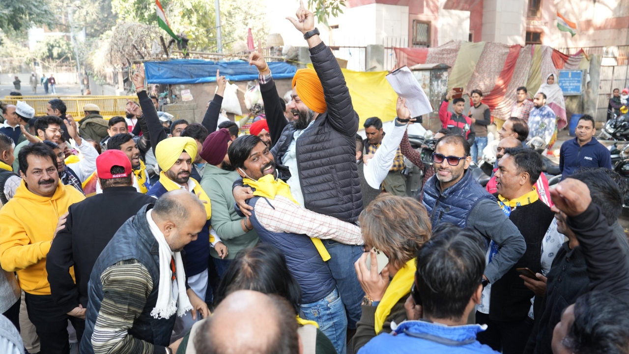 AAP supporters celebrate outside a counting centre at Gole Market, in New Delhi. Credit: PTI Photo