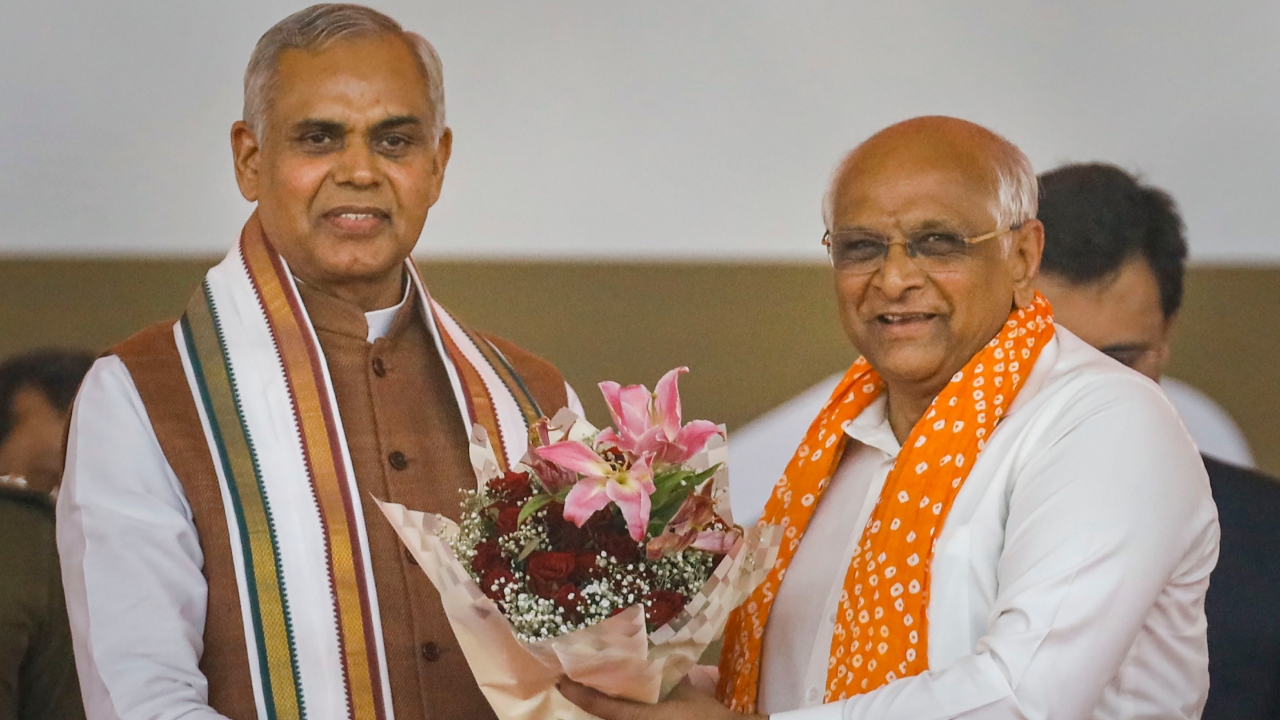 Governor Acharya Devvrat presents a bouquet to BJP leader Bhupendra Patel during the latter's oath-taking ceremony as Gujarat Chief Minister, in Gandhinagar. Credit: PTI Photo