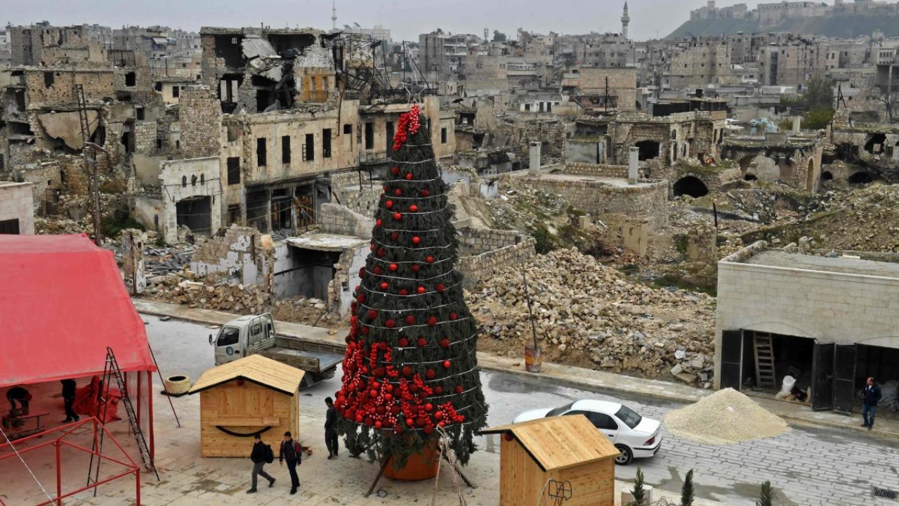 Workers set up a Christmas tree at al-Hatab square, one of the oldest in Syria's northern city of Aleppo. Credit: AFP Photo