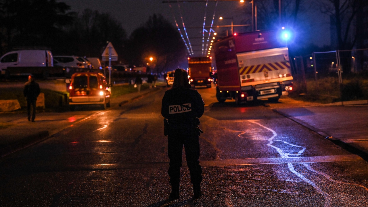 Policemen guard a security perimeter as firefighters and rescuers work in a building of the Mas-Du-Taureau quarter where a fire caused many victims, including children, in Vaulx-en-Velin, east of Lyon, south-eastern France, on December 16, 2022. Credit: AFP Photo