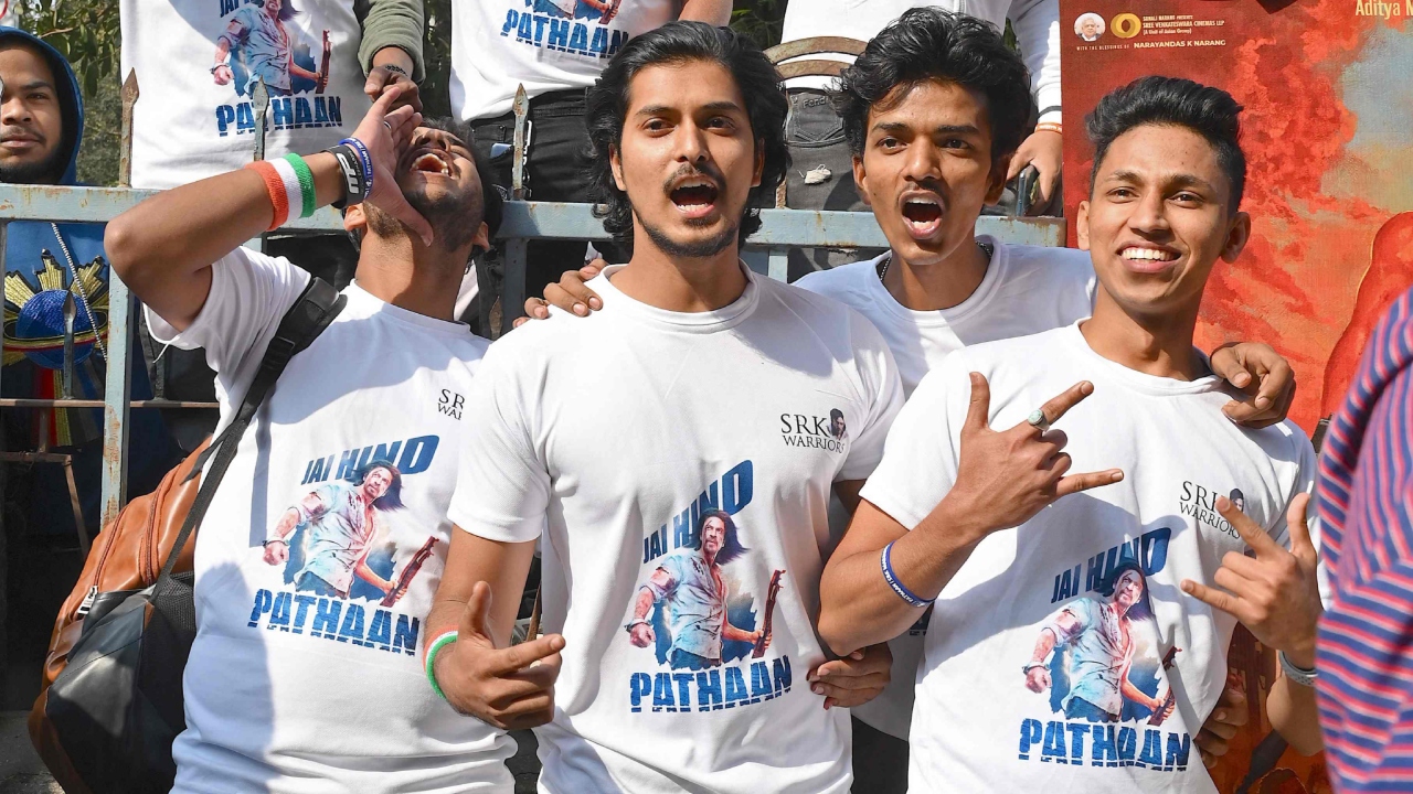 Fans of SRK pose outside a cinema hall as they arrive to watch 'Pathaan' in Mumbai. Credit: AFP Photo