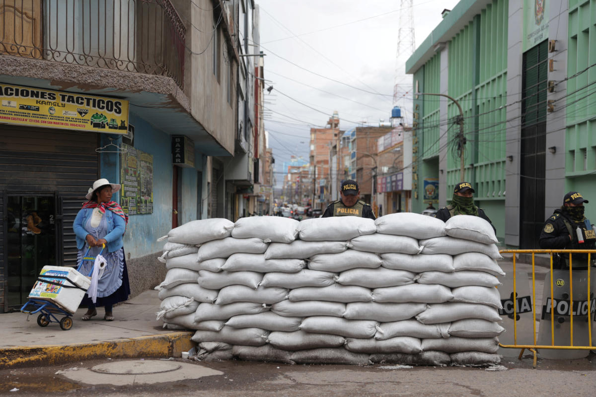 A woman walks next to a police barricade on a street, as protests and roadblocks in Peru's southern Andes have hardened after Congress failed to bring forward elections, in Juliaca, Peru February 7, 2023. Credit: REUTERS/Pilar Olivares