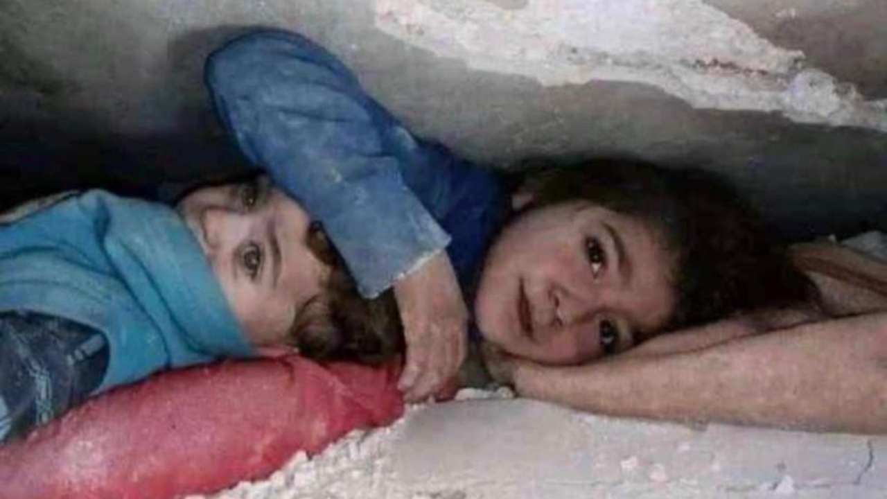 A little Syrian girl protecting her younger brother under debris in Syria. Credit: Twitter/@mhdksafa