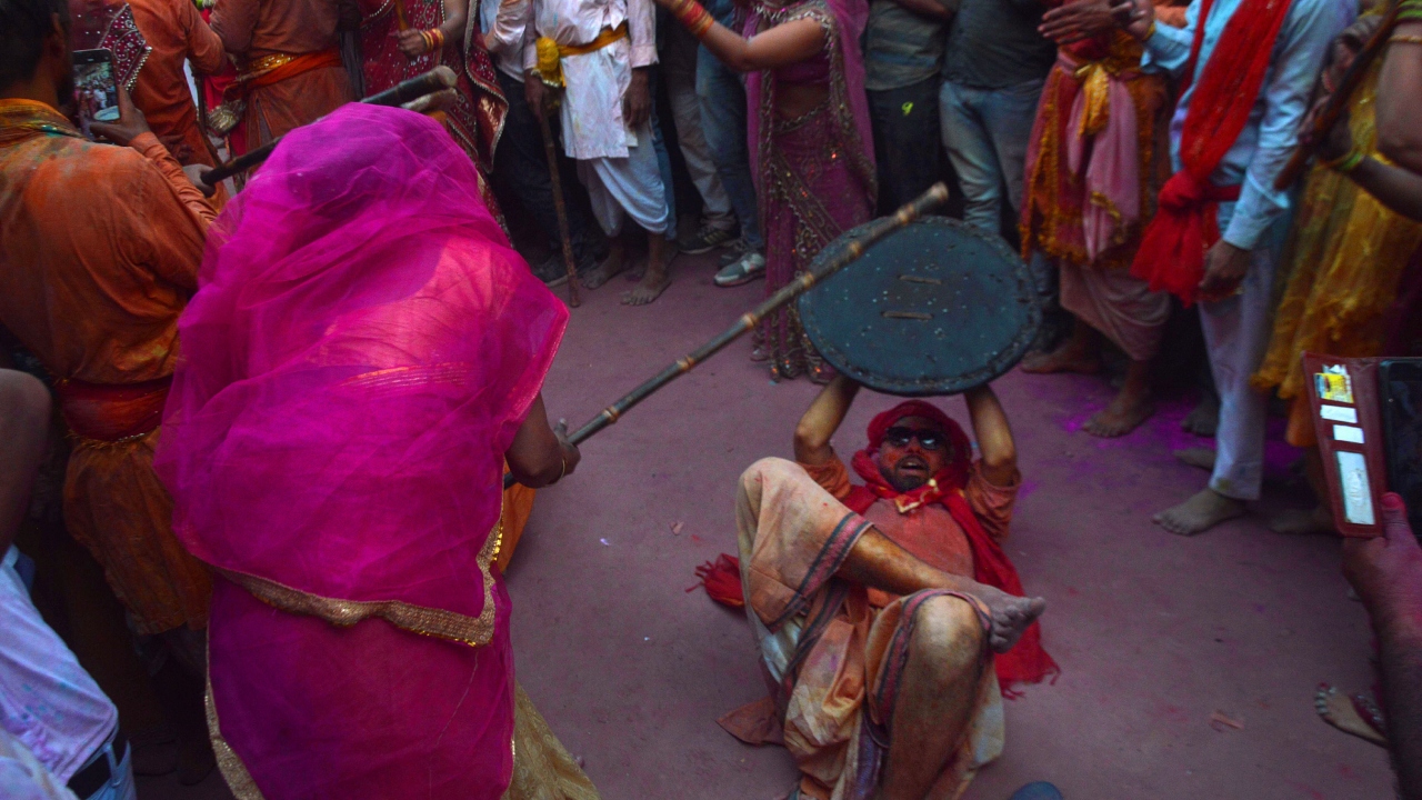 Historical town Barsana -- the land of 'Radha Rani' -- witnessed a spectacle when men drenched women in colours and the women wielding batons 'playfully' hit the men to drive them away. Credit: PTI Photo