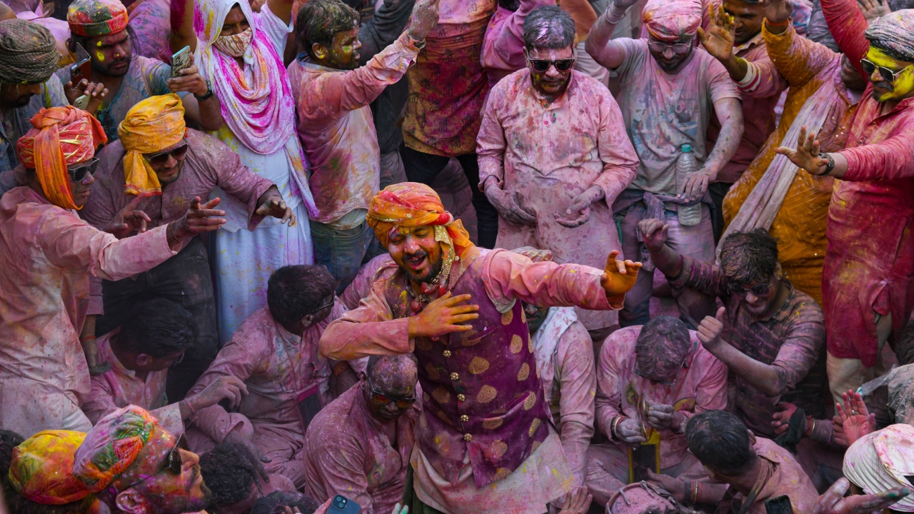 An artist performs as others look on during the Holi festival in Nandgaon. Credit: PTI Photo