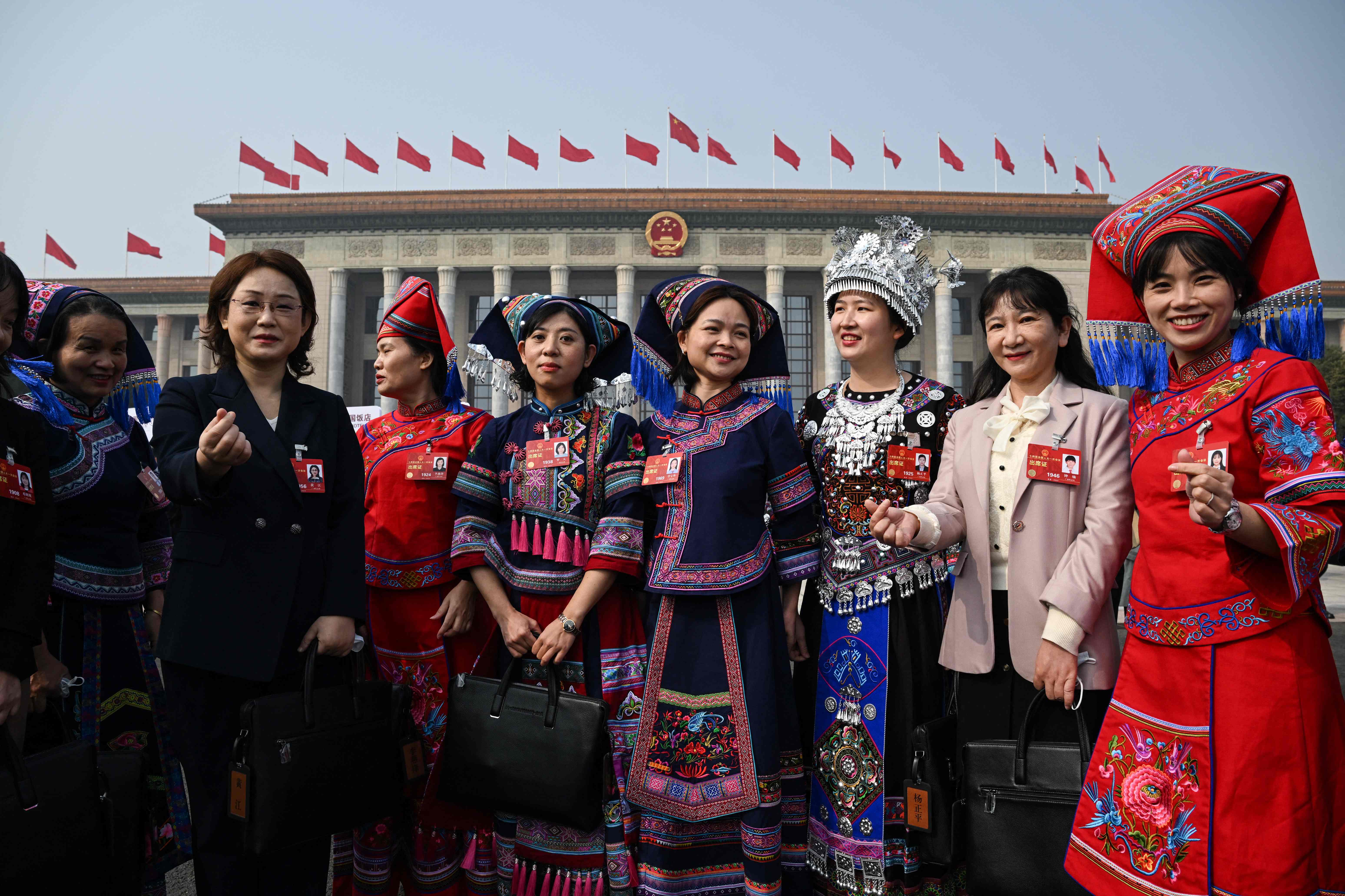 Ethnic minority delegates pose for photos after the opening session of the National People's Congress (NPC) at the Great Hall of the People in Beijing. Credit: AFP Photo