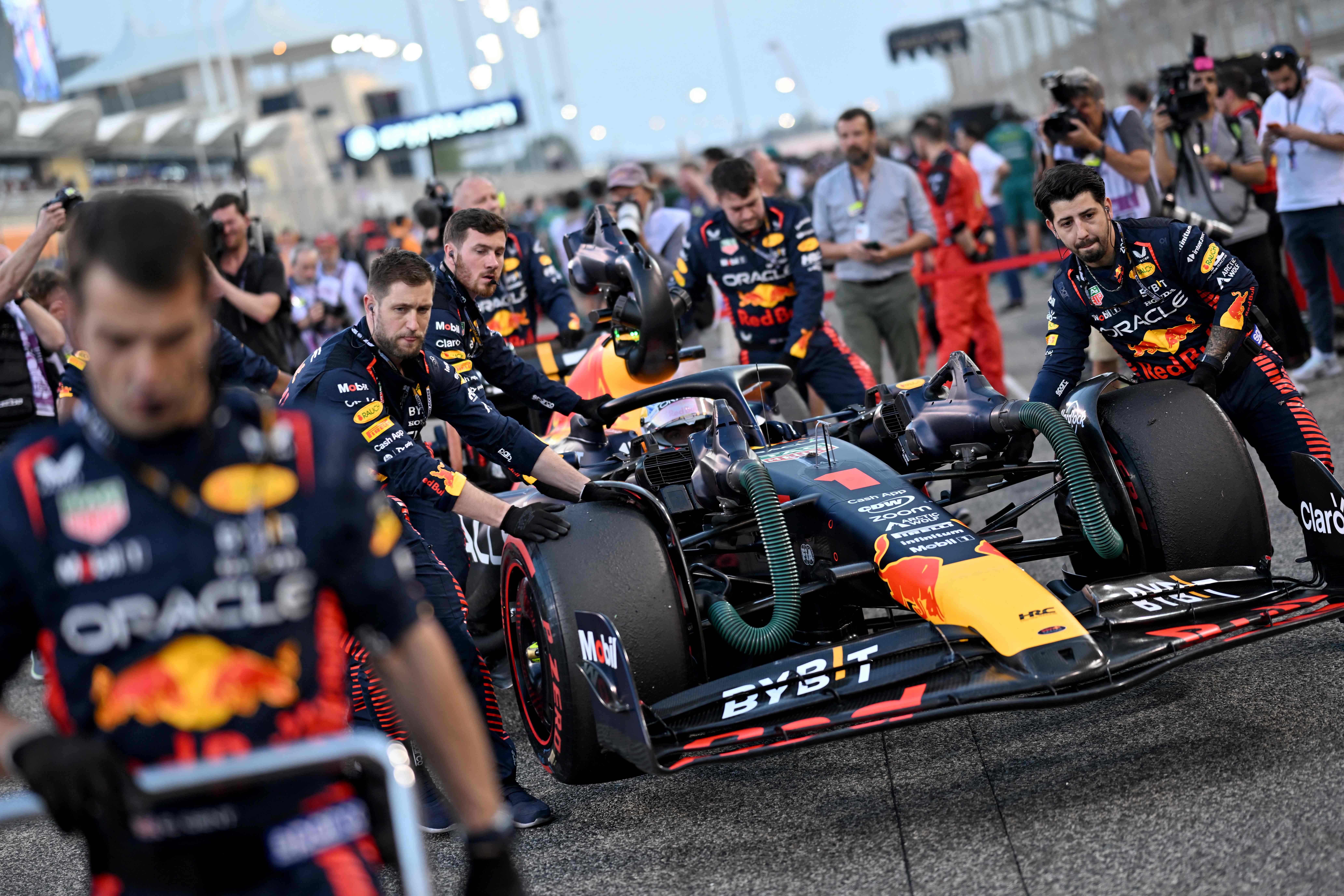 Mechanics push the car of Red Bull Racing's Dutch driver Max Verstappen before the start of the Bahrain Formula One Grand Prix at the Bahrain International Circuit in Sakhir. Credit: AFP Photo