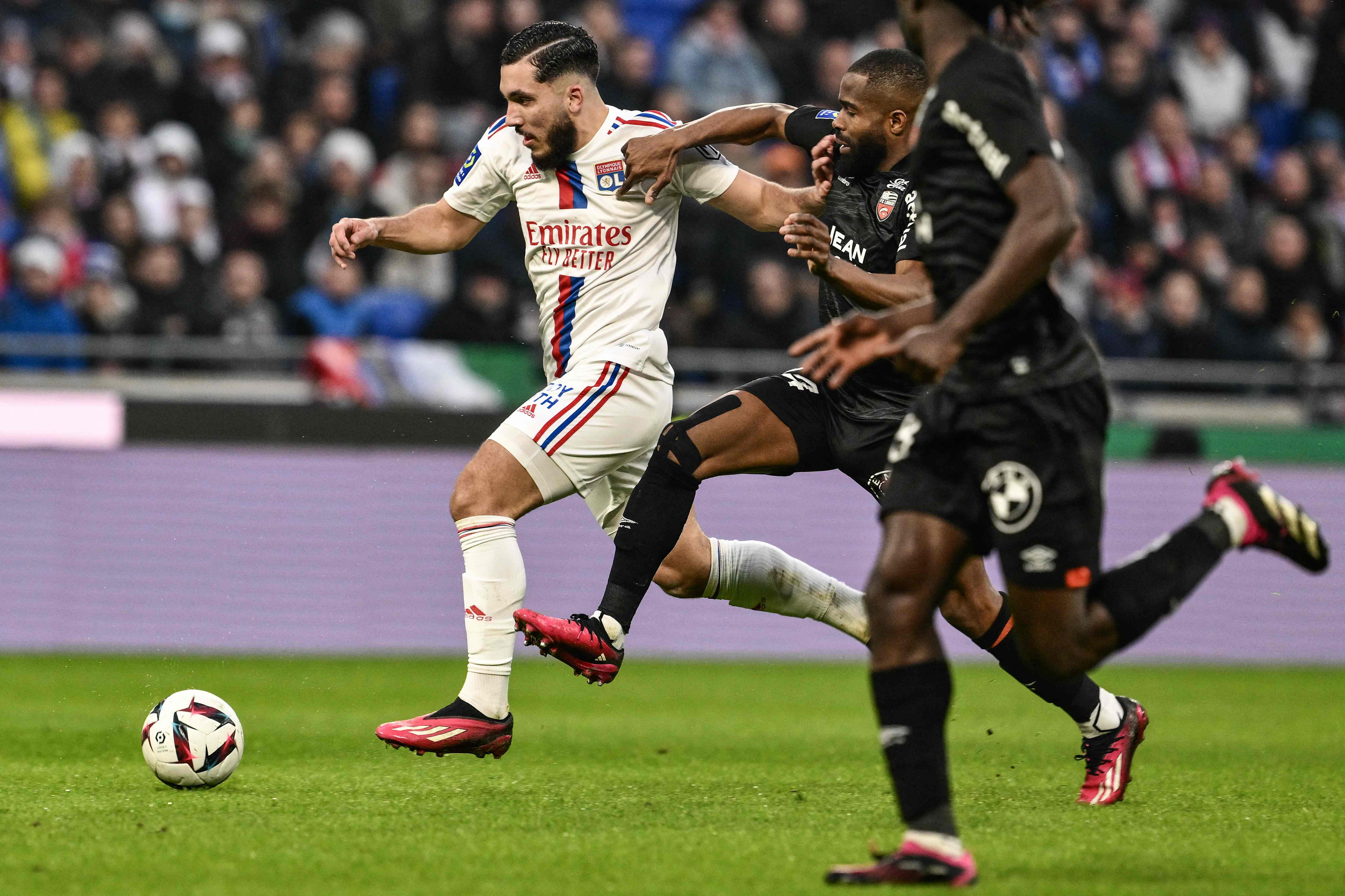 Lyon's French midfielder Rayan Cherki (L) vies with Lorient's Congolese forward Gedeon Kalulu (C) during the French L1 football match between Olympique Lyonnais (OL) and FC Lorient (FCL) at the Groupama Stadium in Decines-Charpieu, central-eastern France. Credit: AFP Photo