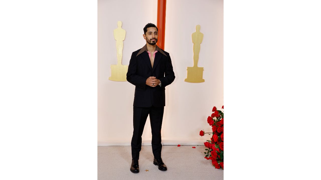 Riz Ahmed, one of the presenters at the Oscars, was seen dressed in a black suit with a pink wool cardigan peeking out. Credit: Reuters Photo