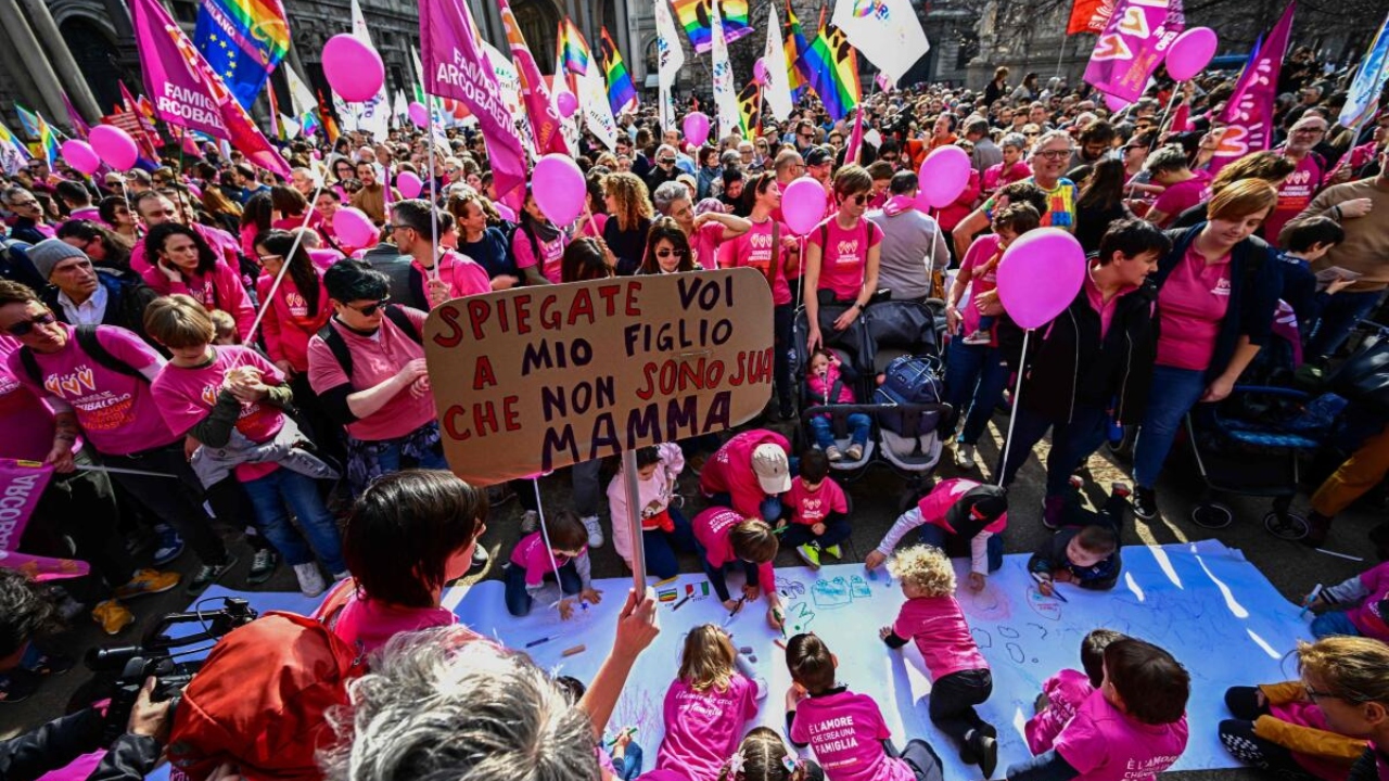 A woman holds a placard reading