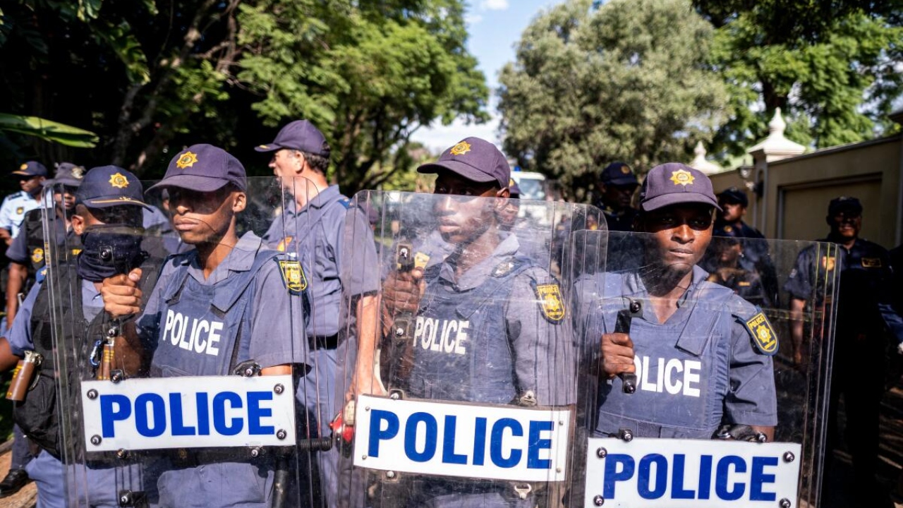 South African Police Service (SAPS) officers prepare riot gear as Economic Freedom Fighters (EFF) protest in front of the presidential Guest House in Pretoria. Credit: AFP Photo