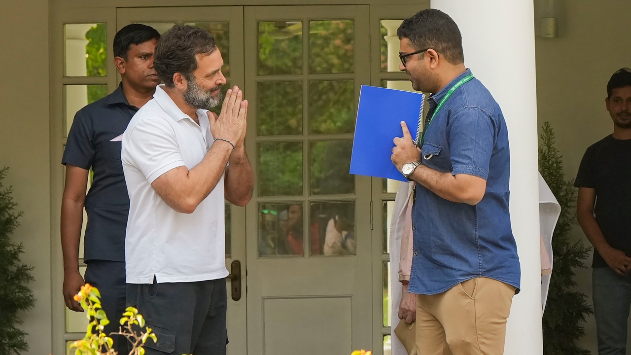 Congress leader Rahul Gandhi greeted a CPWD official after handing over the keys of the bungalow. Credit: PTI Photo