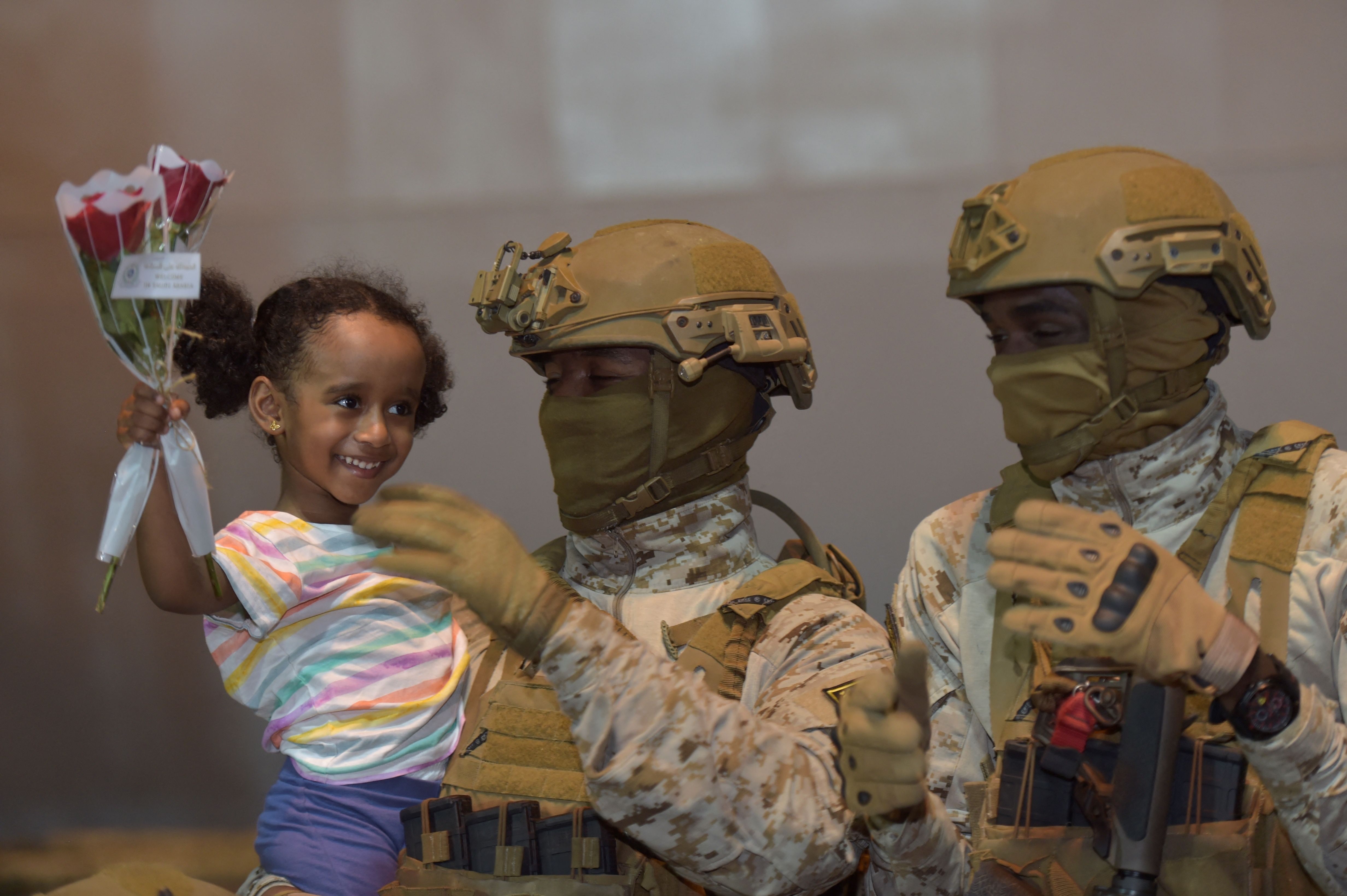 A member of the Saudi armed forces carries a girl who arrived at King Faisal navy base in Jeddah, following a rescue operation from Sudan. Credit: AFP Photo