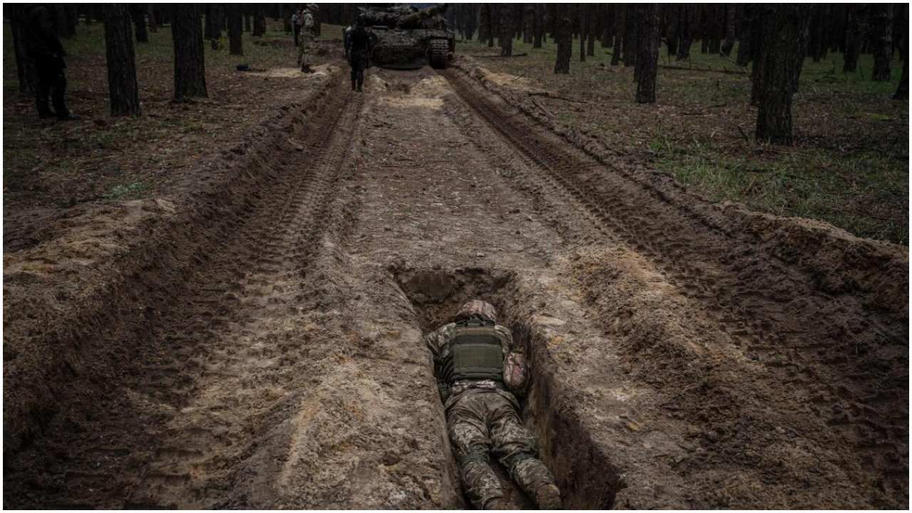 A Ukrainian serviceman lies in a trench during a military exercise in the Kharkiv region on May 1, 2023. Credit: AFP Photo