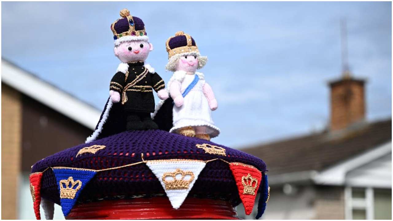 A photograph taken on May 2, 2023 shows a knitted Britain's King Charles III (L) and Britain's Camilla, Queen Consort displayed on a post office box next, in Rhyl, north Wales, ahead of the coronation ceremony of Charles III and his wife, Camilla, as King and Queen of the United Kingdom and Commonwealth Realm nations, on May 6, 2023. Credit: AFP Photo