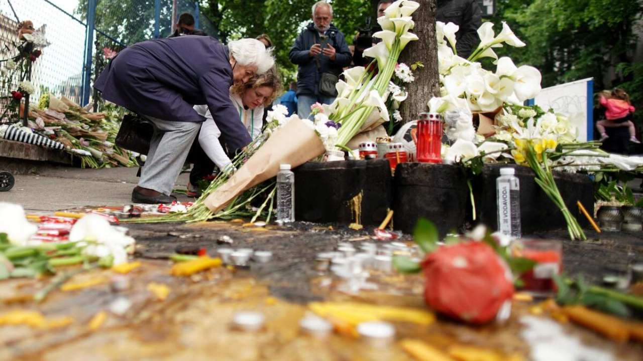 People light candles for the victims outside the Vladislav Ribnikar elementary school in the capital Belgrade, on May 4, 2023, a day after a 13-year-old suspect shot dead eight fellow students and a security guard after allegedly drawing up a kill list. Credit: AFP Photo