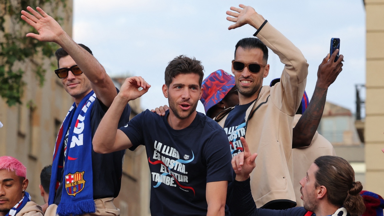 Barcelona's Polish forward Robert Lewandowski, Spanish midfielders Sergi Roberto and Sergio Busquets wave during the victory parade. Credit: AFP Photo
