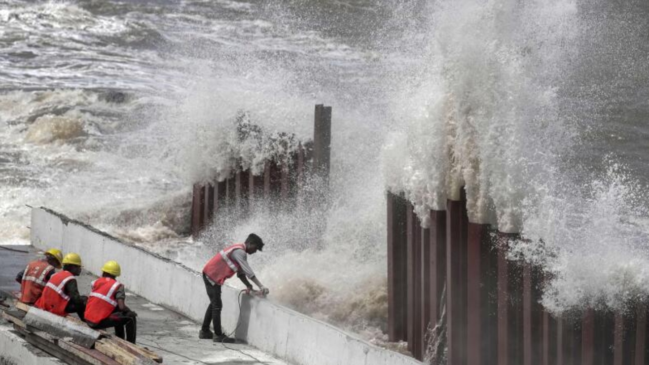 Construction workers at Marine Drive as high tidal waves lash the shore ahead of the landfall of Cyclone Biparjoy, in Mumbai, Thursday, June 15, 2023. Credit: PTI Photo