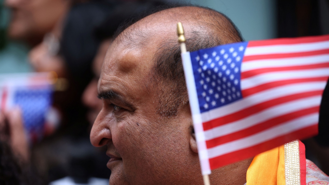 A supporter of Prime Minister Narendra Modi holds a US flag as he waits for Modi's arrival outside the Lotte Hotel in New York City. Credit: Reuters Photo