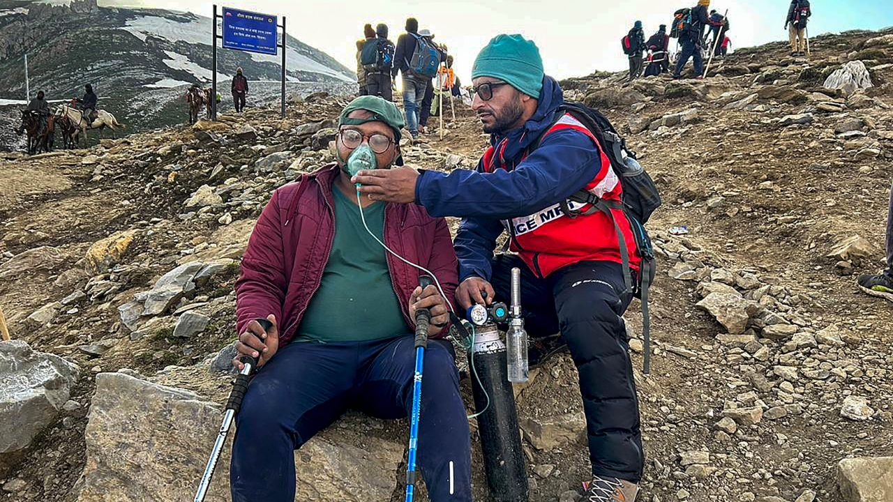 J&K Police Mountaineering Rescue Team (MRT) member rescues an Amarnath yatri while shifting him from Barimarg medical camp to Domail, in Anantnag