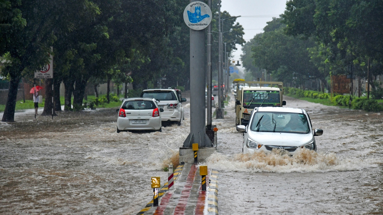 Vehicles make their way on a waterlogged road amid heavy monsoon rains in Chandigarh. Credit: PTI Photo