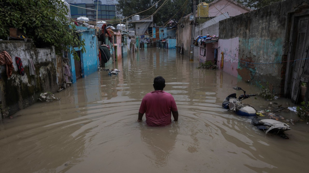 A man walks through a flooded alley at a residential colony, after water rose from the river Yamuna due to heavy monsoon rain, in New Delhi. Credit: Reuters Photo