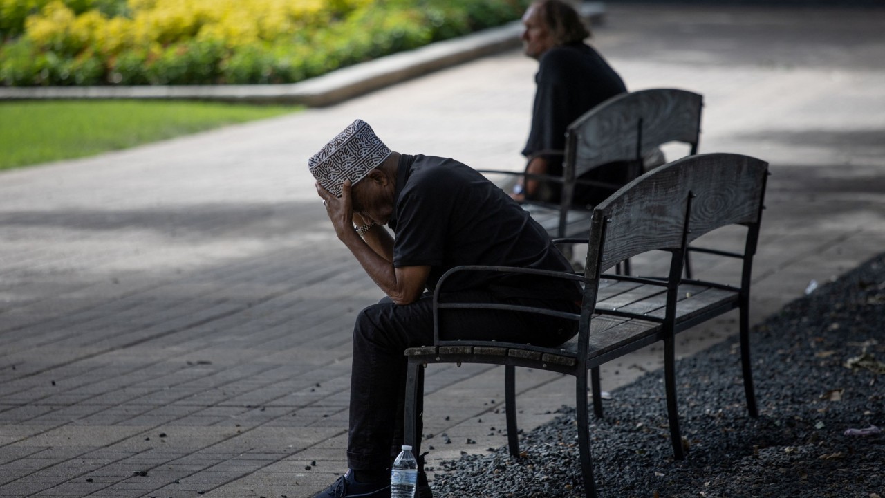 Men take cover on a city bench under trees during hot weather in downtown Houston, Texas. Credit: Reuters Photo