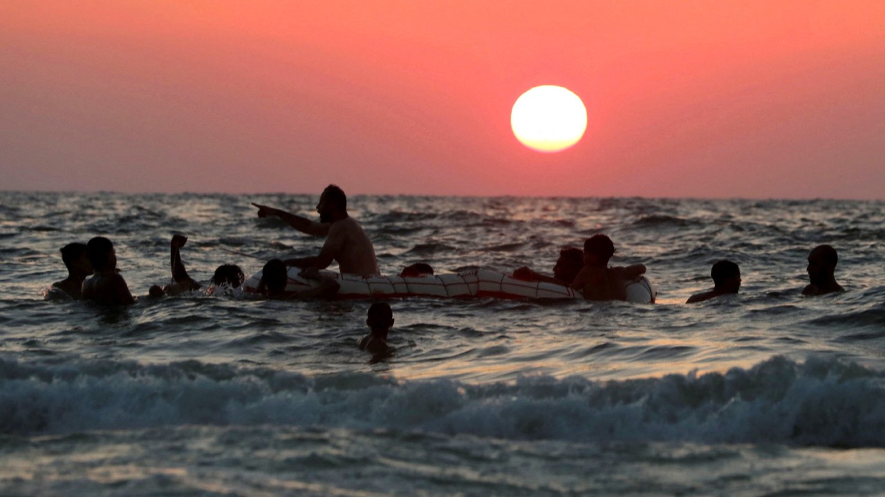 People swim during sunset at a public beach amid a heatwave, in the Mediterranean city of Alexandria. Credit: Reuters Photo