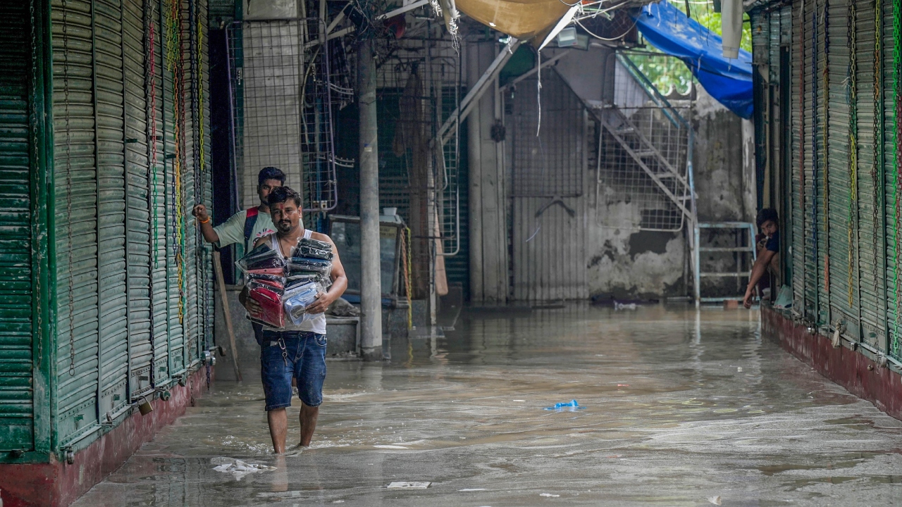 Shopkeepers during the clean-up of their establishments at Monastery market after the floodwater receded, in New Delhi. Credit: PTI Photo