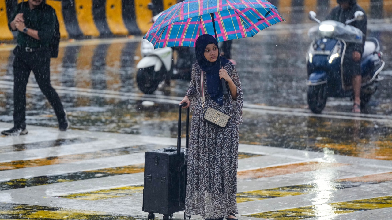 A young woman crosses the road amid monsoon rains in Mumbai. Credit: PTI Photo