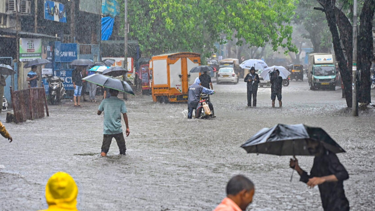 People wade through a waterlogged road amid monsoon rains at Andheri, in Mumbai, Friday, July 21, 2023. Credit: PTI Photo
