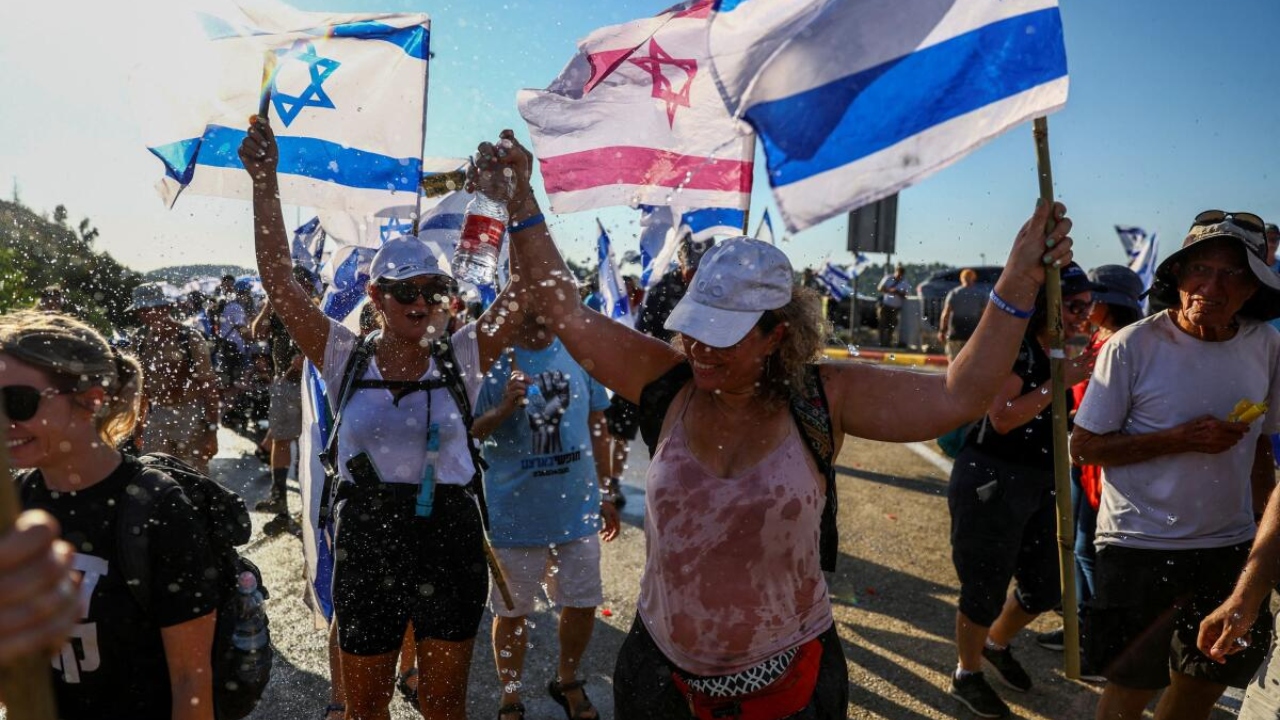 Protesters hold flags as they march in demonstration against Israeli Prime Minister Benjamin Netanyahu and his nationalist coalition government's judicial overhaul on a road in Shoresh, Israel, which leads to Jerusalem, July 21, 2023. Credit: Reuters Photo