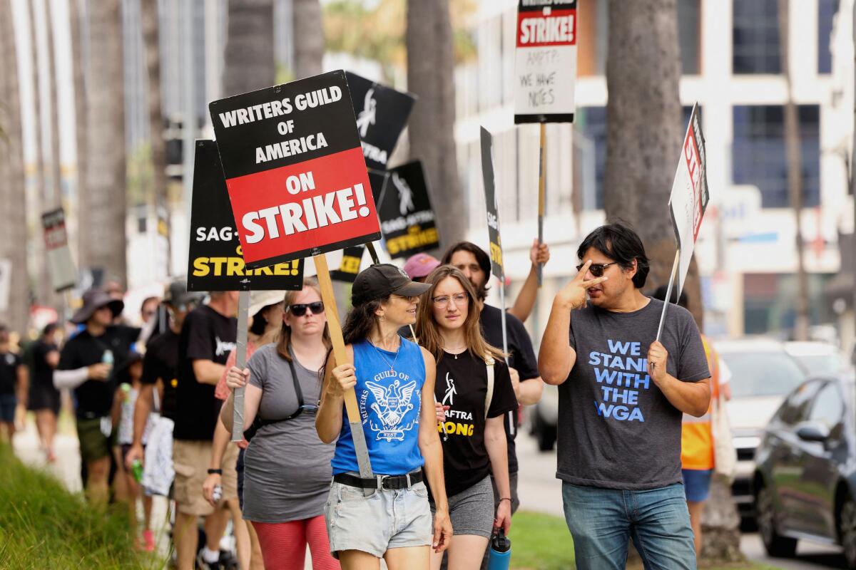 SAG-AFTRA actors and Writers Guild of America (WGA) writers walk the picket line during their ongoing strike, in Los Angeles Credit: Reuters Photo