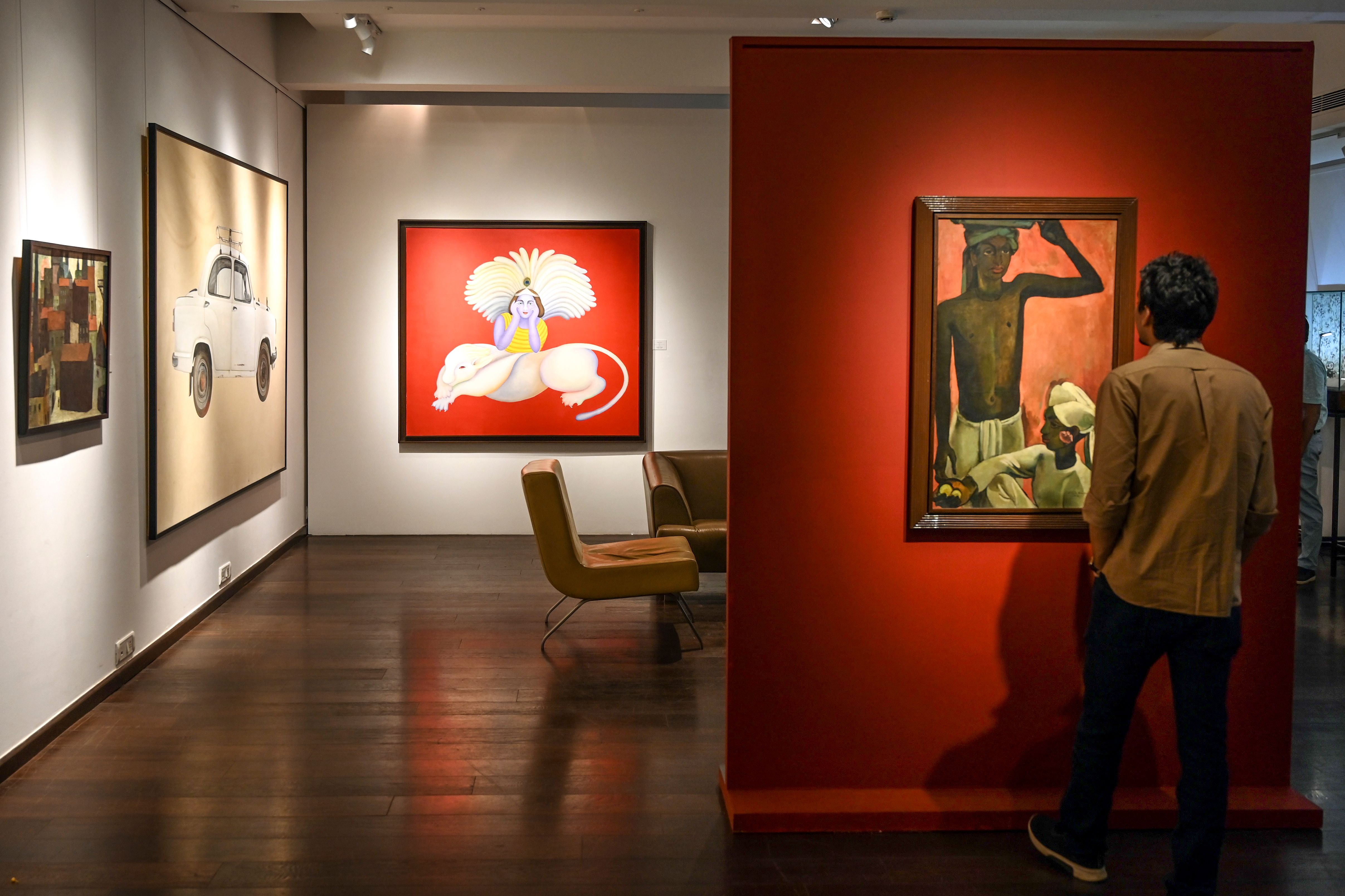 In this photo taken on February 24, a staff member stands in front of a painting displayed during a media preview at the Saffron Art Gallery, in Mumbai on February 24, 2020, ahead of the Spring Live Auction being conducted by Saffronart on behalf of the Tax Recovery Officer of India's Income Tax Department. (Credit: AFP)