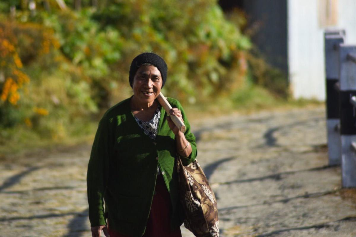An Angami woman returning home from work