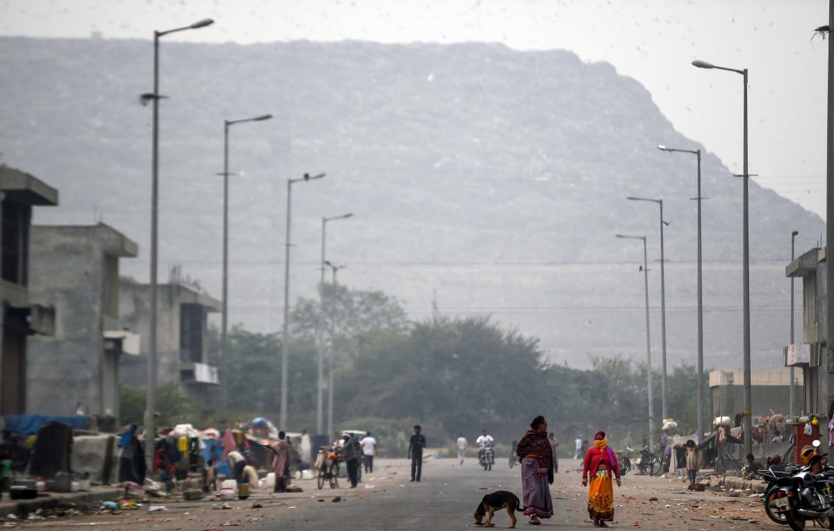 Residents walk near the Ghazipur landfill site in New Delhi. 