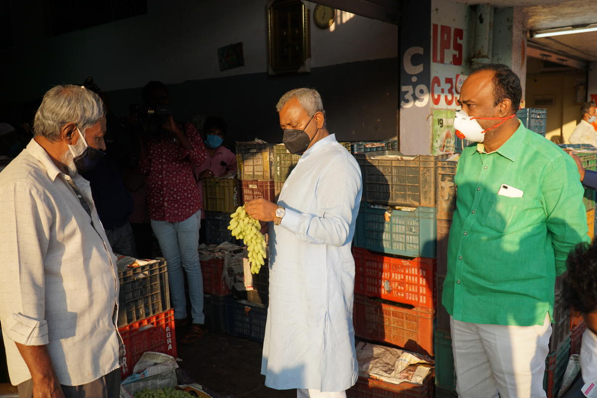 Cooperation Minister S T Somashekar examines grapes at the fruit market on Huskur Road outside Electronics City. DH PHOTO/AKHIL KADIDAL 