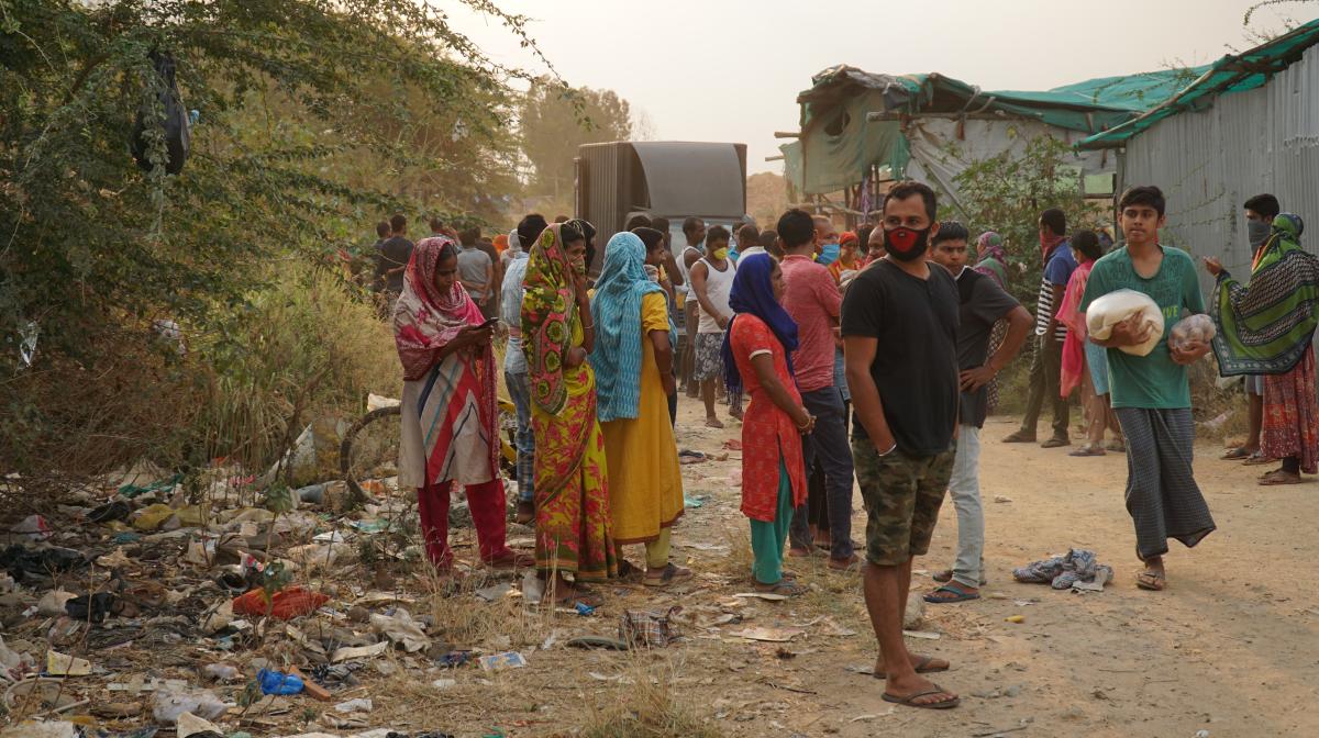 An angry crowd watches as volunteers distribute food to only those who have food coupons. A volunteer hands out rations (inset). (R) Geetha (40) with her grandson. DH PHOTOS/Akhil Kadidal