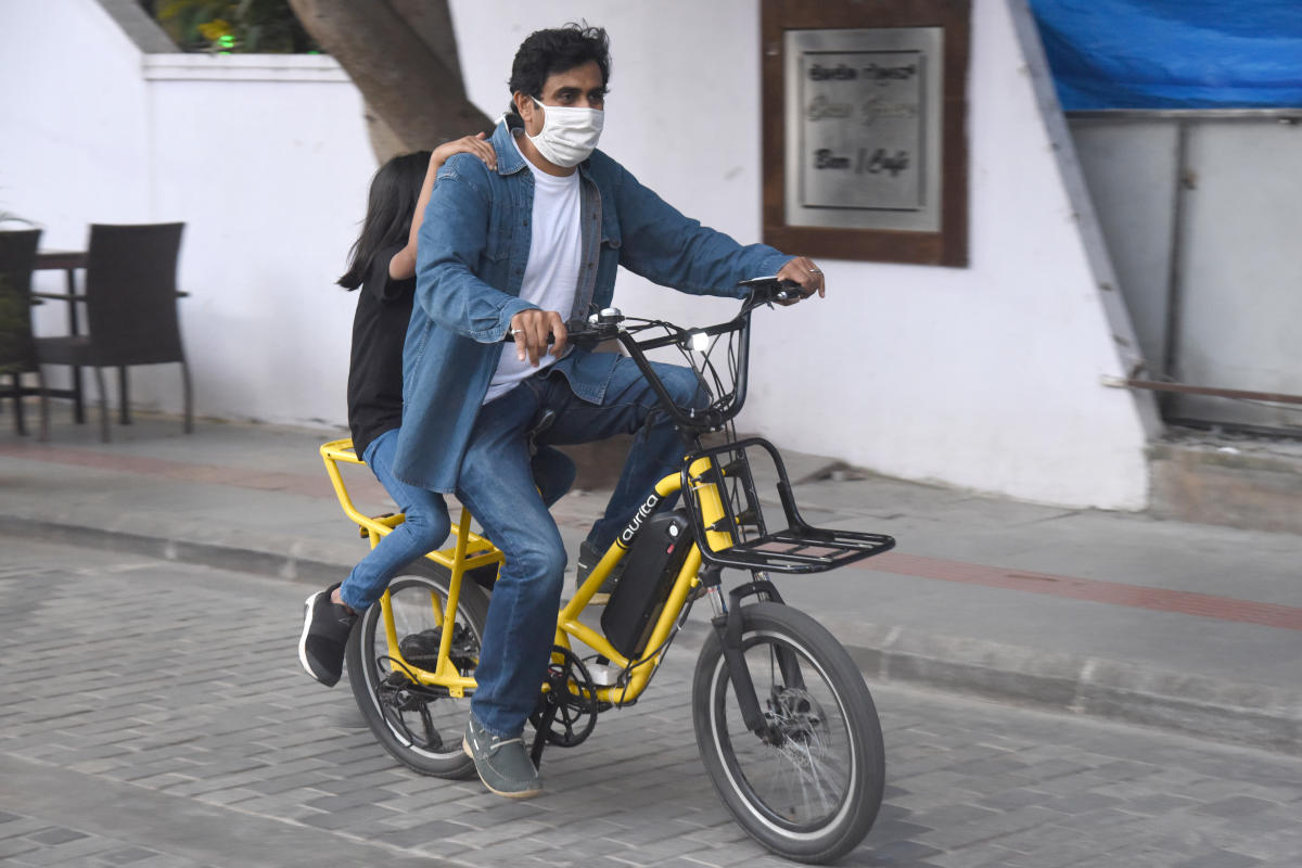 A man rides a bicycle with his child. Credit: DH photo/SK Dinesh.