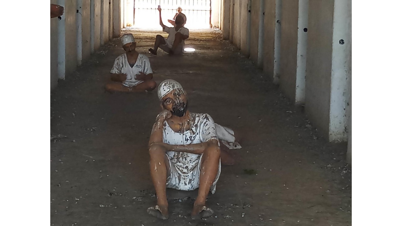Models of prisoners are stained with bird droppings and a thick coat of dirt.