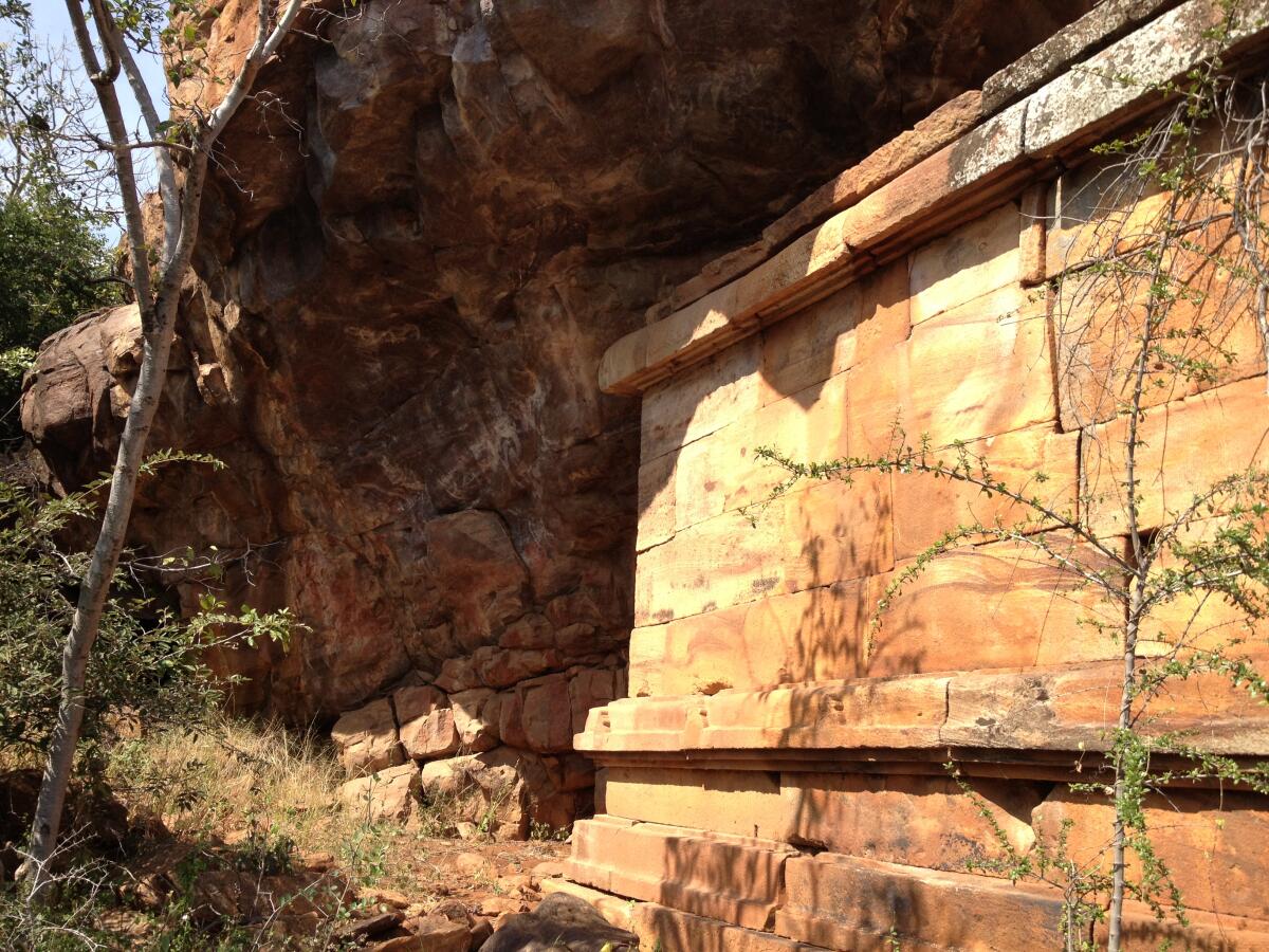 The temple inserted below the overhang of the sandstone cliff.